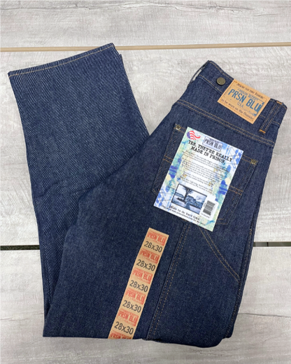 A pair of hanging blue work jeans with reinforced knee panels on front, two front pockets and a coin pocket. Standard button and zipper closure and belt loops. Includes suspender buttons.