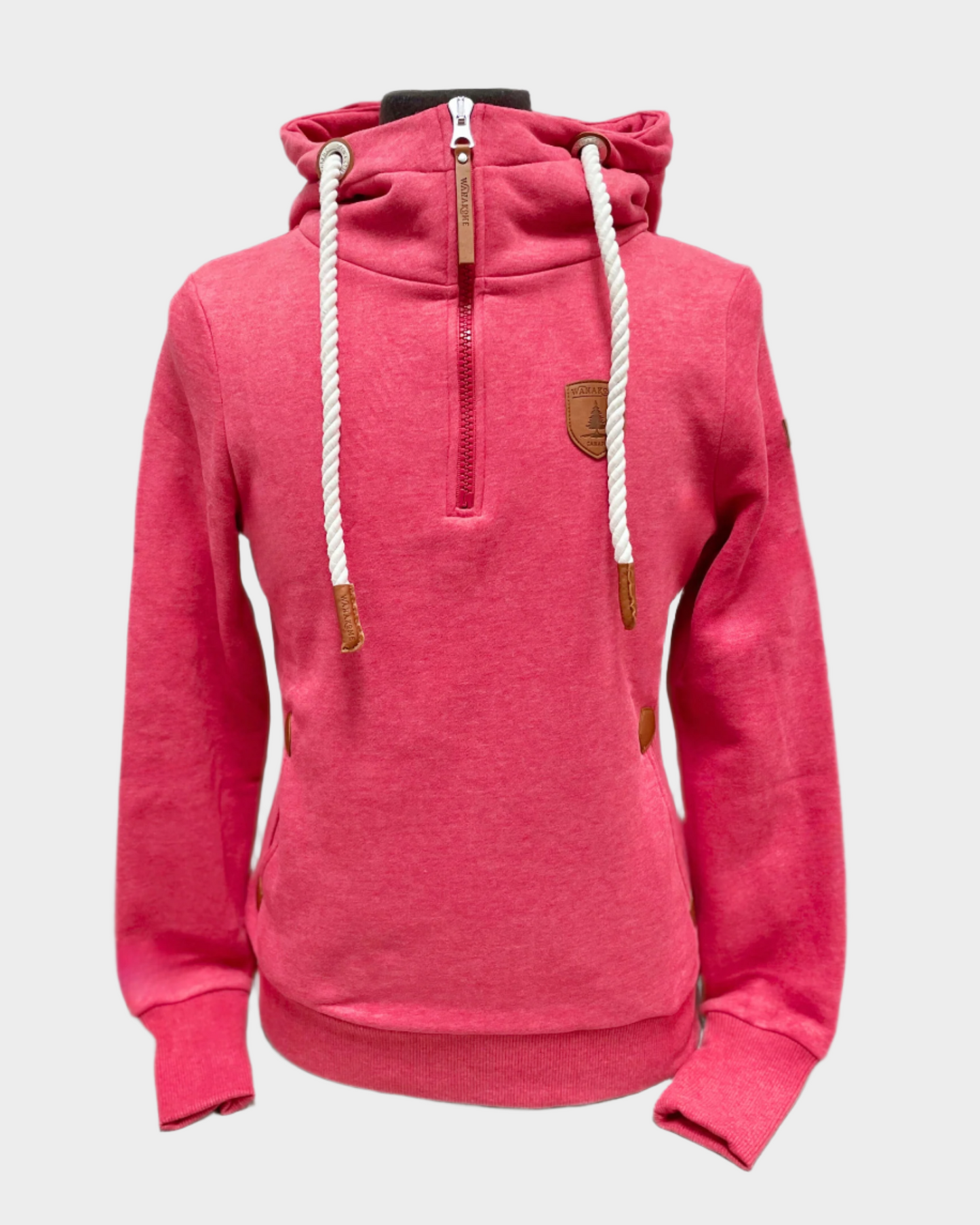 Womens pullover hoodie with partial zip. Hood with white adjustable rope drawstrings and vegan leather caps. Half zipper. Side pockets. Brushed French terry interior. Wanakome patch logo embroidered on sleeve and chest. Has thumbholes on wrist cuff. Shown in chilli, a bright heather pink.