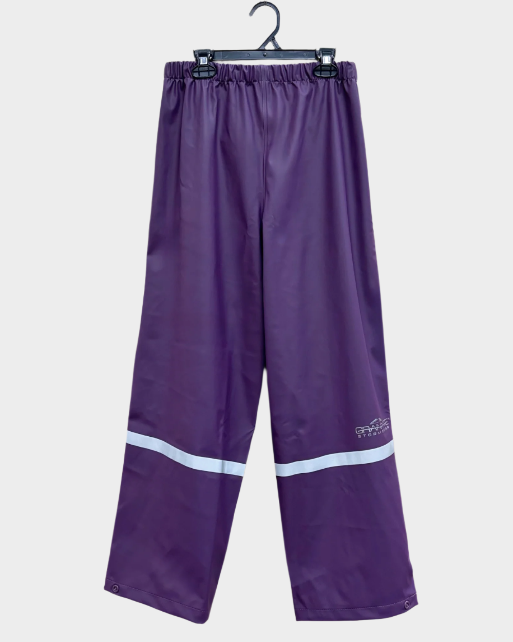 kids purple PU rain pants with reflective strip across lower legs. Button on ankle seams. Elastic waist.