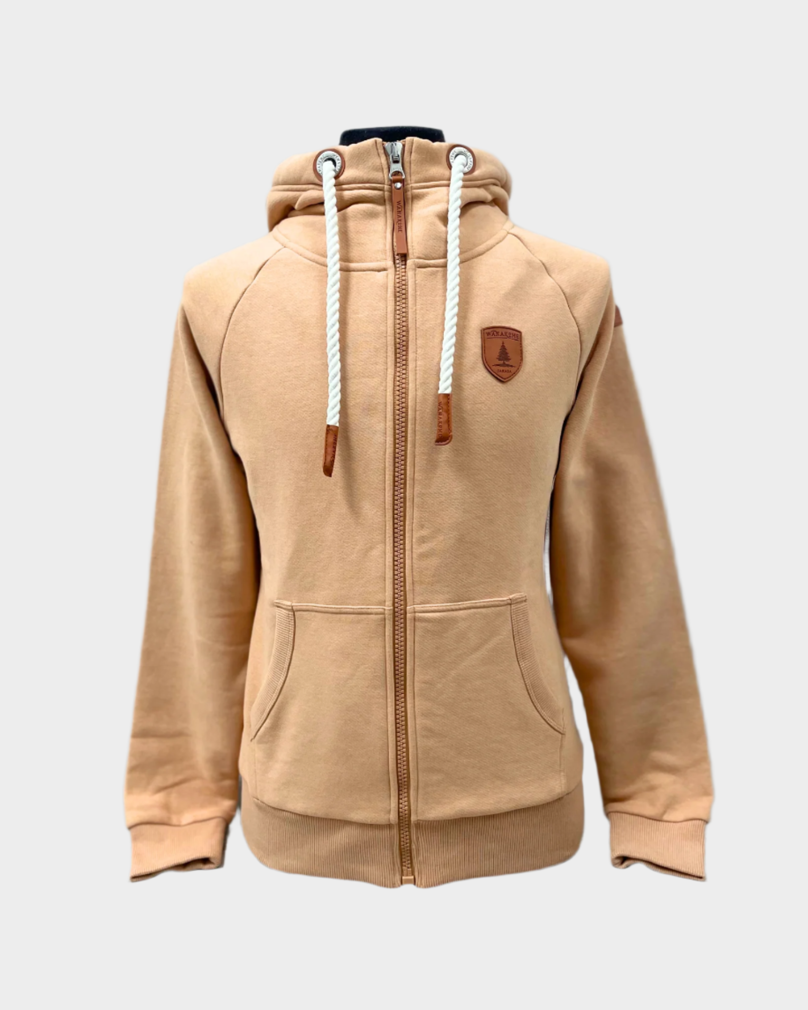 Womens Full zip hoodie with cowl neck. White rope drawstrings. Front side pockets. Leather patch on left chest and shoulder. ribbed wrist cuffs and bottom hem. Shown in cookie a light tan.