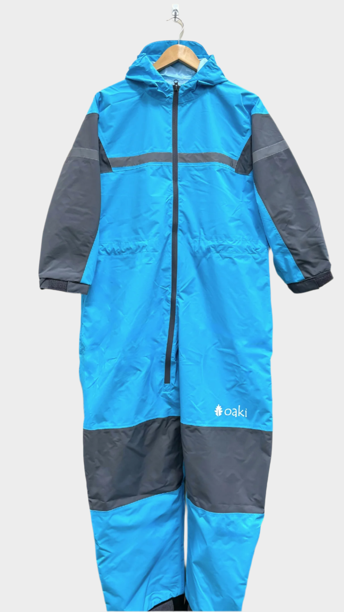 Kids rain suit with attached hood, grey color blocking on top of arms and across shins with safety reflective strips. Shown in a varient of celestial blue, a lighter brighter blue. 