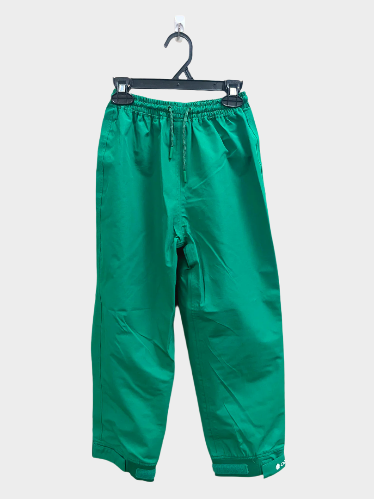 A pair of kids rain pants with an elastic waistband and drawstring. Ankles have a neoprene covered velcro adjustment. Shown in forest green