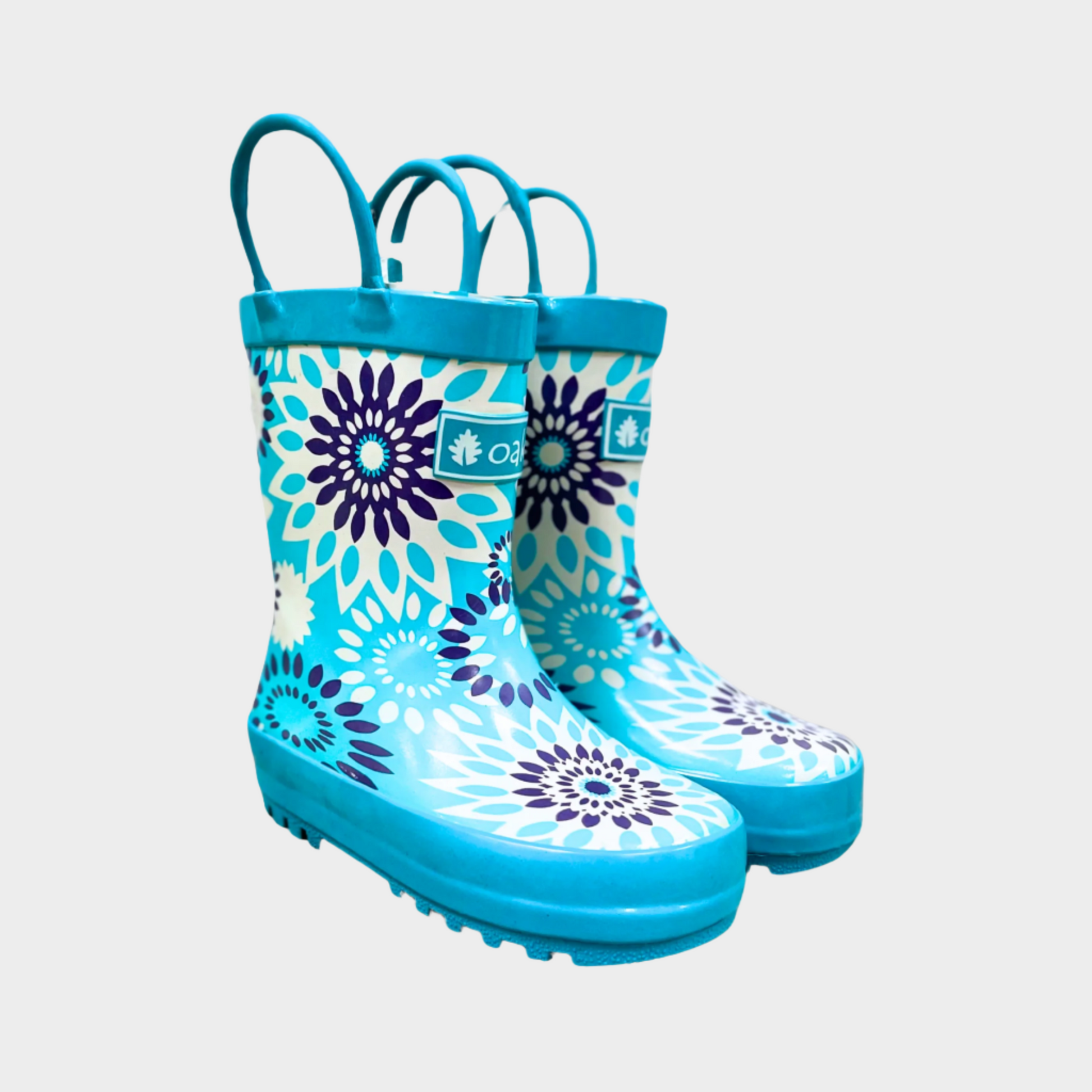 Kids rubber rain boots with blue snow burst pattern rubber and oaki logo. Black tread and loop handles.