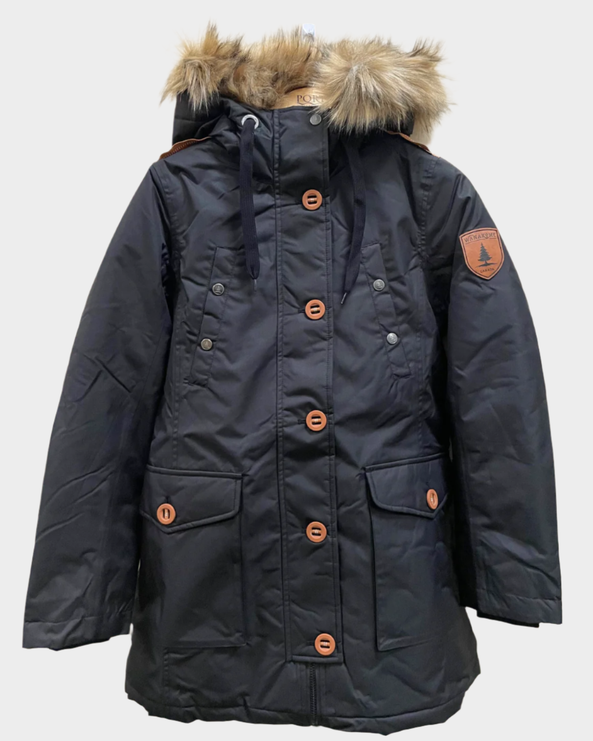 Womens waterproof parka in black. Four pockets on front, contrast buttons, inner backpack slings.